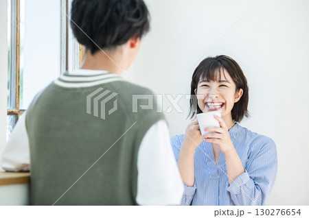 コーヒーを飲みながら会話する若い女性 130276654
