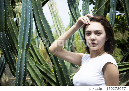 サボテンの前に立つきれいな女性 130278077