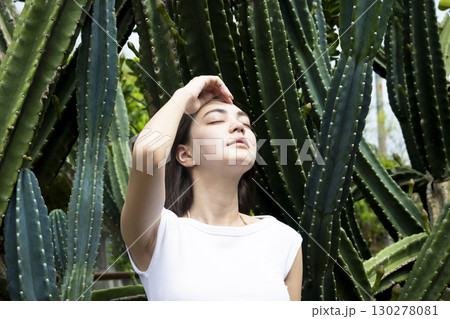 サボテンの前に立つきれいな女性 130278081