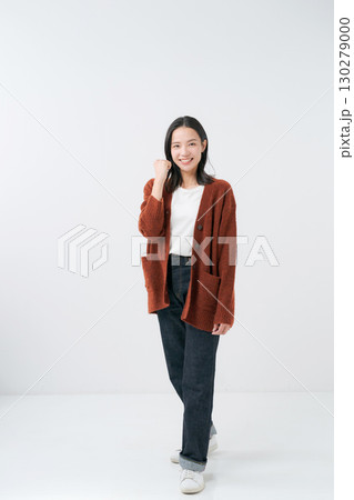 ガッツポーズをするニットの女性 130279000