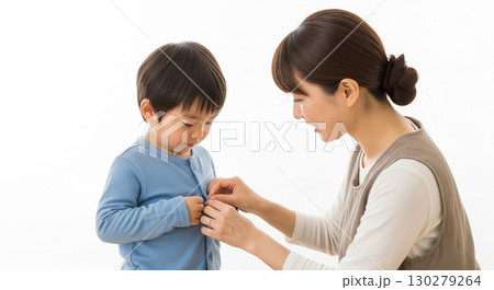 子供の洋服のボタンを掛けてあげているお母さん 子供の洋服のボタンを掛けてあげているお母さん 130279264