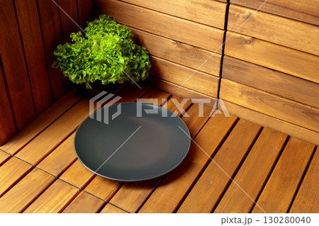 Empty black plate on natural wooden background. 130280040
