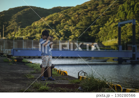 ＜素材＞夏休みの朝に港で写真を撮る男の子 130280566