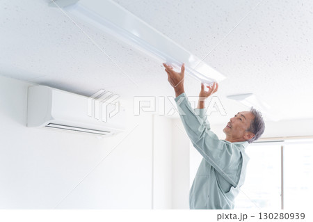 ライトの取付け工事をするシニア男性作業員 130280939