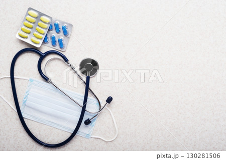 Healthcare medical background of stethoscope, face mask and pills flat lay on table with copy-space Healthcare medical background of stethoscope, face mask and pills flat lay on table with copy-space 130281506