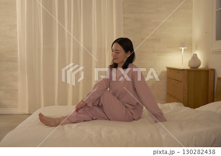 ベッドの上でストレッチする女性 130282438