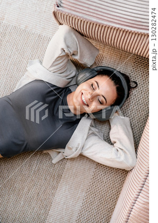 Woman relaxing at home, enjoying music after work. Woman relaxing at home, enjoying music after work. 130282474