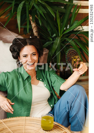 Portrait of woman with hair rollers during slow morning. 130282498