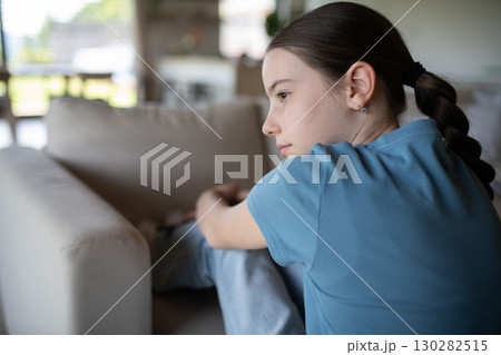 Teenage girl struggling with emotions in living room. Teenage girl struggling with emotions in living room. 130282515