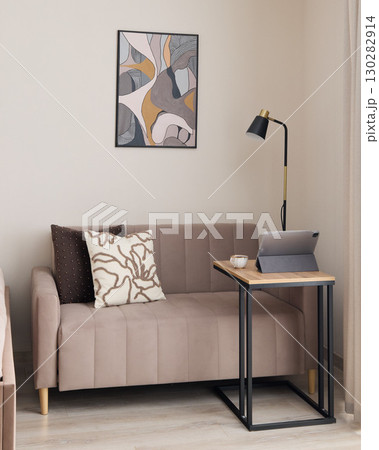 A modern and cozy living room featuring a stylish sofa along with captivating art pieces 130282914