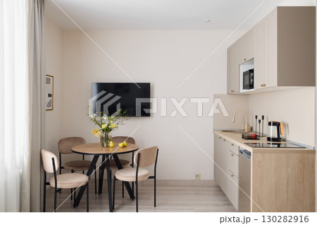 This modern kitchenette features a delightful dining space, creating a cozy atmosphere 130282916
