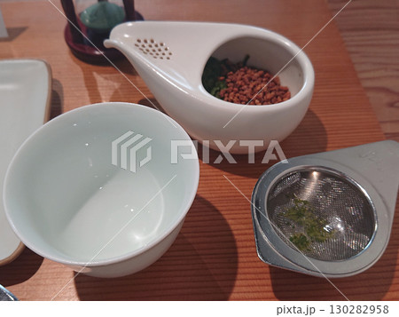 玄米茶の入った急須と湯呑みと茶こし 130282958