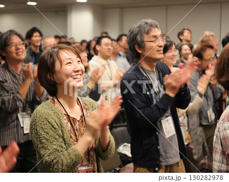 イベント会場で講演に拍手を送る参加者たちの笑顔と共感（ビジネス 教育 コミュニケーション） 130282978