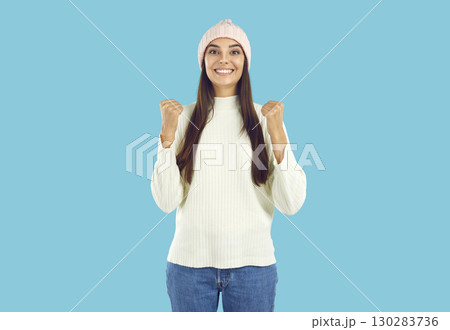Portrait of happy beautiful young woman in winter clothes smiling and doing yes gesture 130283736