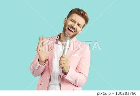 Handsome emotional young man singing over microphone and gesturing Handsome emotional young man singing over microphone and gesturing 130283760