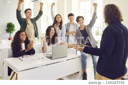 Cheerful multiracial students having fun celebrating success during teamwork in lecture. Cheerful multiracial students having fun celebrating success during teamwork in lecture. 130283781
