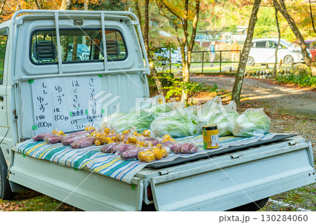 荷台で無人の野菜販売をしている軽トラック 130284060