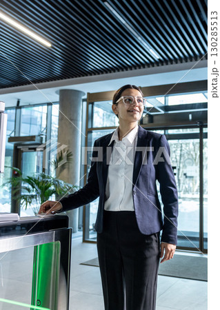 Elegant businesswoman standing near the security check point in the business center 130285513