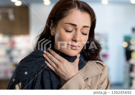 Dark-haired young woman having a sore throat and suffering from pain 130285692