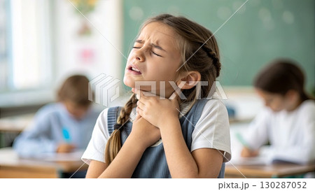 Young Girl with Sore Throat in Classroom Setting 130287052