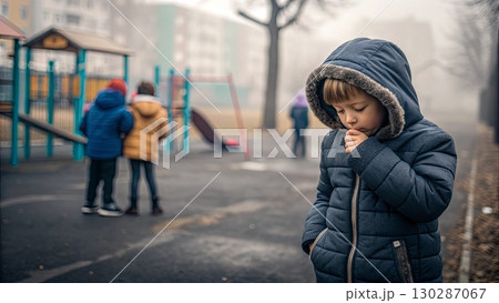 Child Coughing in Winter Coat at Foggy Playground 130287067