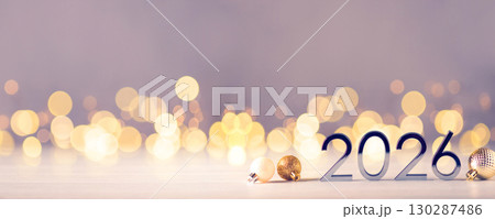 Metal numbers 2026 on a white table with Christmas decorations and bokeh lights. Happy New Year 2026 is coming concept. 130287486