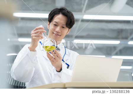 研究所で実験をする白衣の若い男性研究者 130288136