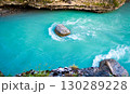 Turquoise river whirlpool around a stone with rocky canyon walls 130289228