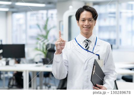 研究所で実験をする白衣の若い男性研究者 130289678
