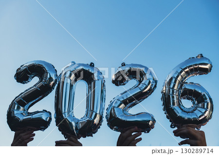 Happy new year 2026 metallic balloons on blue sky background. Greeting card silver foil balloons numbers Christmas holiday concept. Celebration party congratulation Happy new year 2026 metallic balloons on blue sky background. Greeting card silver foil balloons numbers Christmas holiday concept. Celebration party congratulation 130289714