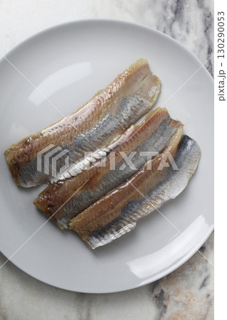 Pieces of herring fillet on a plate View from above. Preparation of fish dishes. horizontal photo Pieces of herring fillet on a plate View from above. Preparation of fish dishes. horizontal photo 130290053