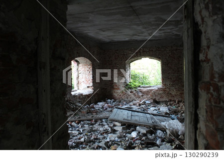 a room in an old ruined house with fragments of brick and plaster 130290239
