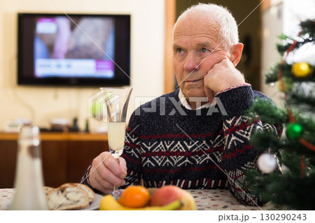 Sad bored older man in warm knitted sweater celebrating New Year Sad bored older man in warm knitted sweater celebrating New Year 130290243