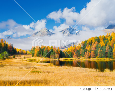 Autumn landscape. Nature. Clouds over the mountains and fall forest. Lake and reflection. Autumn landscape. Nature. Clouds over the mountains and fall forest. Lake and reflection. 130290264