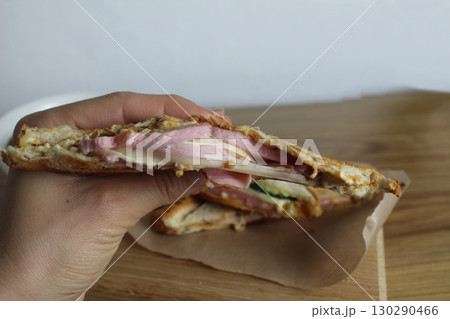 Girl breaks a cheese sandwich with her hands. breakfast. Processed cheese 130290466