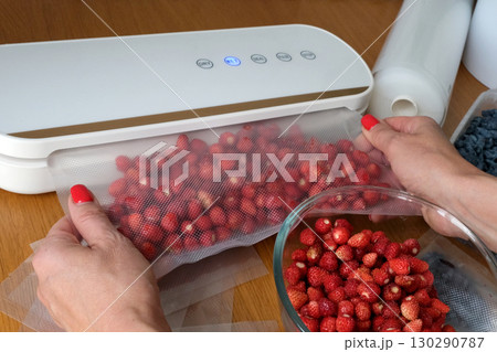 Vacuum sealer of strawberries, honeysuckle in bag, packaging for long-term storage . Vacuum packing machine 130290787