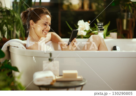 Woman with Smartphone Relaxing in a Bubble Bath 130290805