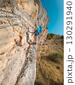 Climber on via ferrata trail, crossing a steep mountain edge 130291940