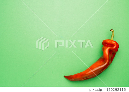 Red chili pepper on green background, minimal food concept 130292116