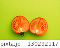 Red tomato halves on green background, minimal food concept 130292117