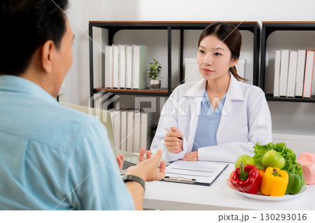 Asian nutritionist consulting patient in clinic, meal plan discussion, healthcare advice. 130293016