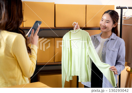 Two asian woman taking picture of clothes for online store, woman collaboration with online seller. 130293042