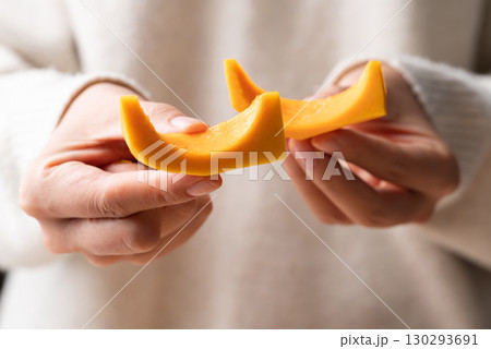 Sliced butternut squash pumpkin holding by woman hand Sliced butternut squash pumpkin holding by woman hand 130293691