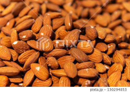 Almond background. Almonds top view background. Whole almond nuts flat lay. Full depth of field. Perfect not AI almond, true photo 130294853