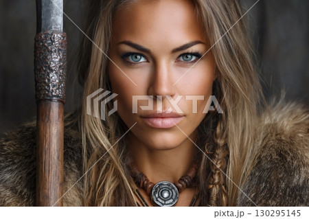 Viking woman posing with spear and fur clothing looking fierce 130295145