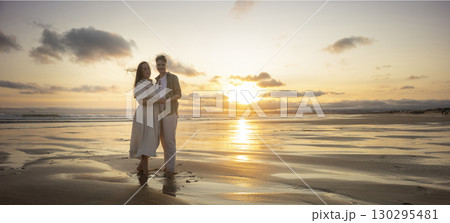 Lesbian couple holding hands and enjoying golden sunset on beach Lesbian couple holding hands and enjoying golden sunset on beach 130295481