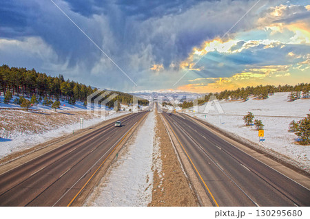 Highway in Rocky Mountains with snow and dramatic sky 130295680