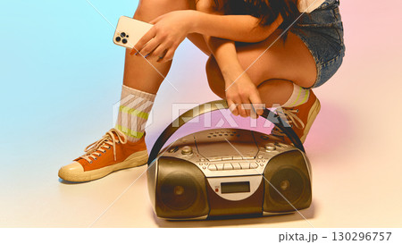 Retro boombox on floor with smartphone in hand Retro boombox on floor with smartphone in hand 130296757