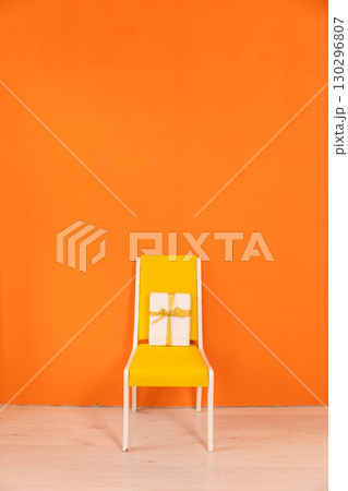 chair with gift in the interior of a yellow orange room 130296807