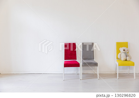 Three vintage chairs of different colors in the interior of an empty white room Three vintage chairs of different colors in the interior of an empty white room 130296820